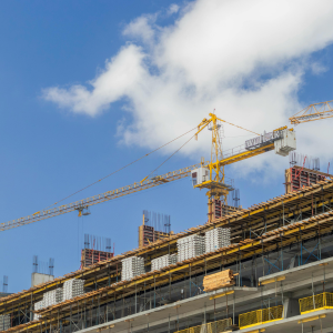 Photo of a large crane onto of a building that is being constructed.