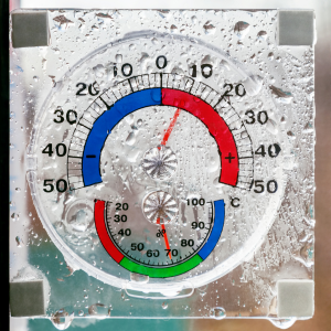 Image of a round thermometer that is wet with condensation.