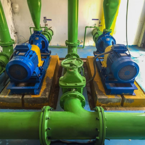 PAD Heaters for Water pumps Image of industrial green pipes and two blue water pumps.